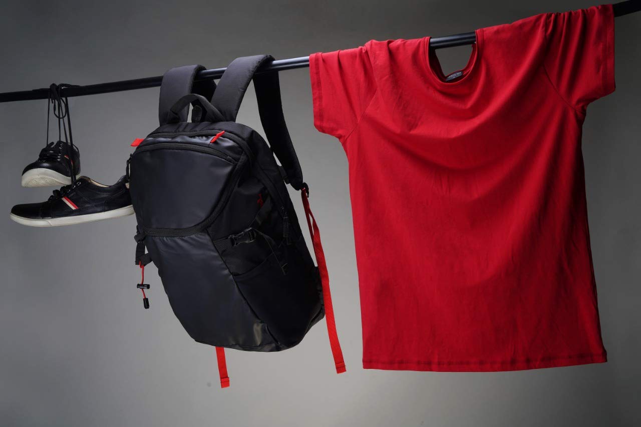 90HILLS backpack displayed with everyday gym and clothing essentials